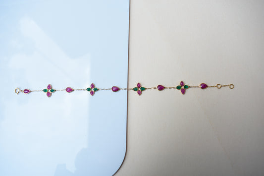 Gold bracelet with ruby and emerald quatrefoil clusters