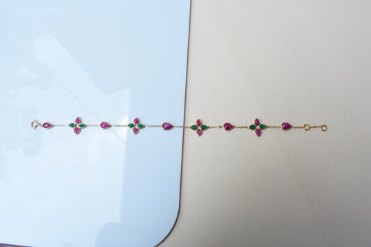 Gold bracelet with ruby and emerald quatrefoil clusters