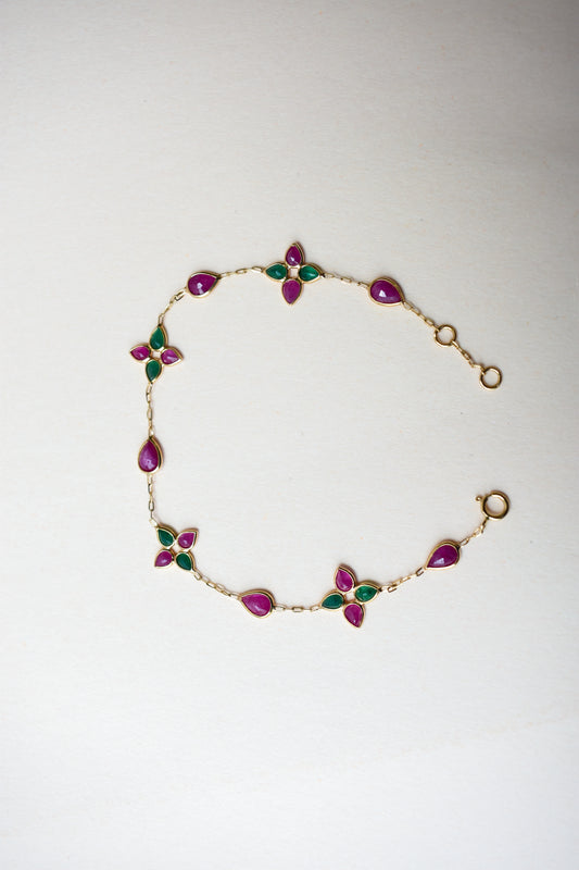 Gold bracelet with ruby and emerald quatrefoil clusters