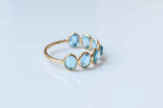 Oval-cut Swiss blue topaz single-row eternity ring in 14K gold