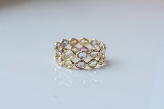 Pear-cut pastel multicolor sapphire eternity ring in 18K gold