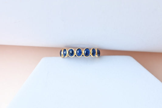 Oval cabochon blue sapphire eternity ring in 18K gold