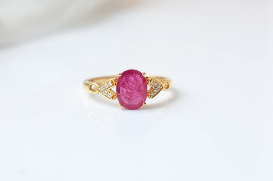 Ruby solitaire ring with diamond shoulder accents in 18K gold