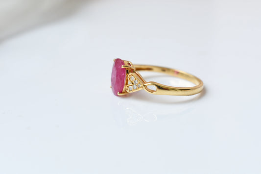 Ruby solitaire ring with diamond shoulder accents in 18K gold