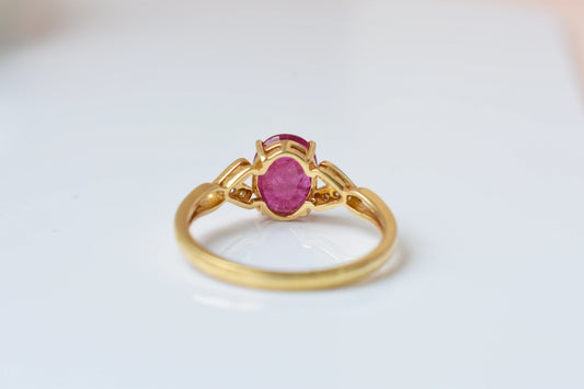 Ruby solitaire ring with diamond shoulder accents in 18K gold