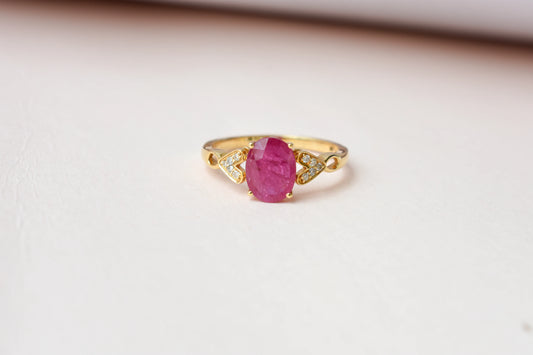Ruby solitaire ring with diamond shoulder accents in 18K gold