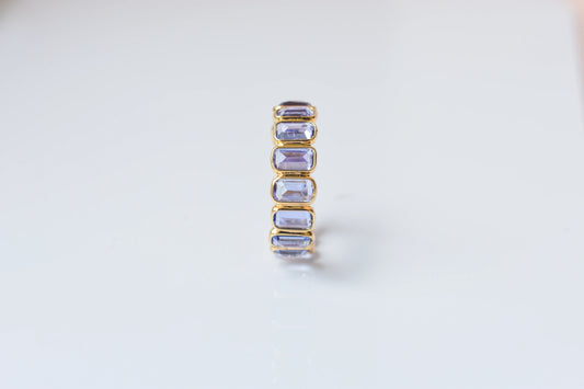 Emerald-cut tanzanite single-row eternity ring in 18K gold