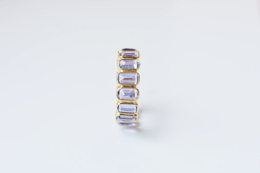 Emerald-cut tanzanite single-row eternity ring in 18K gold
