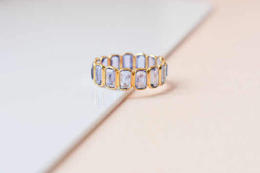 Emerald-cut tanzanite single-row eternity ring in 18K gold
