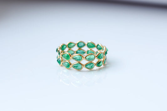 Pear-cut emerald lattice eternity ring in 18K gold with bezel setting