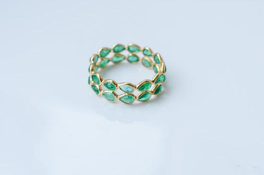 Pear-cut emerald lattice eternity ring in 18K gold with bezel setting
