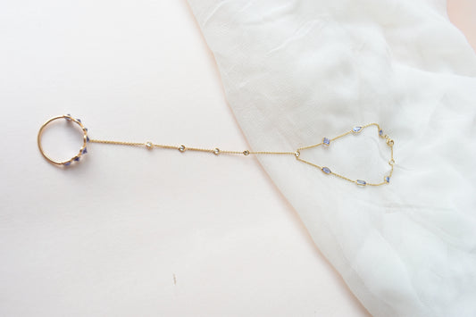 18K gold hand chain with tanzanite ring and diamond wrist accents