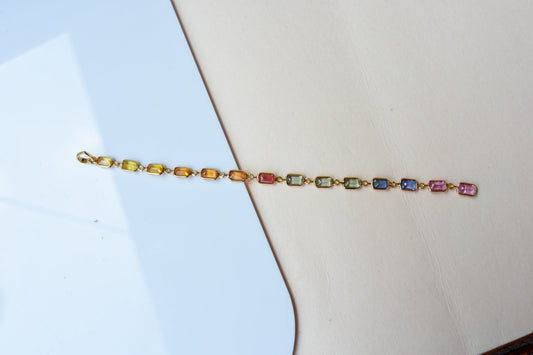 18K gold pendant with a graduated line of bezel-set multicolor sapphires