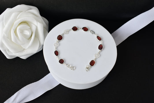 Garnet station bracelet with bezel-set stones and filigree flower links in 925 silver