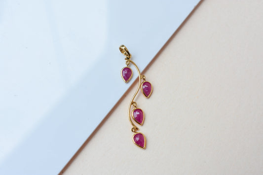 18K gold pendant with four bezel-set pear rubies on a vine design