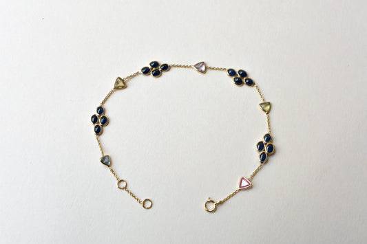 18K gold bracelet with blue sapphire clusters and multi-color trillion sapphire accents