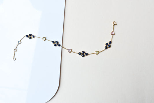18K gold bracelet with blue sapphire clusters and multi-color trillion sapphire accents