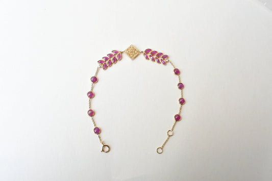 18K gold bracelet with round ruby stations and a diamond accent