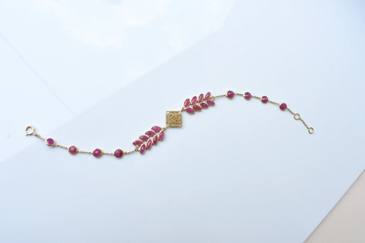 18K gold bracelet with round ruby stations and a diamond accent