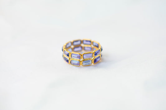Baguette-cut tanzanite double-row eternity ring in 18K gold with bezel setting