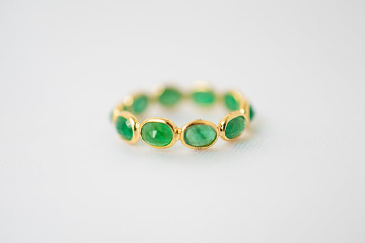 Oval-cut emerald gemstone eternity ring in 18K gold with bezel setting