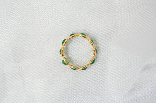 Oval-cut emerald gemstone eternity ring in 18K gold with bezel setting