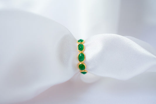 Oval-cut emerald gemstone eternity ring in 18K gold with bezel setting