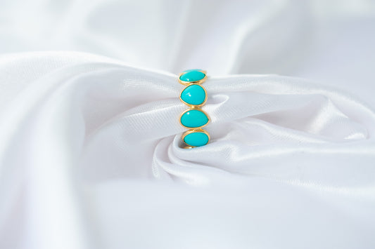 Oval cabochon turquoise gemstone eternity ring in gold with bezel setting
