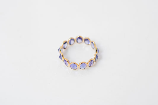 Oval-cut tanzanite gemstone eternity ring in 18K gold with bezel setting