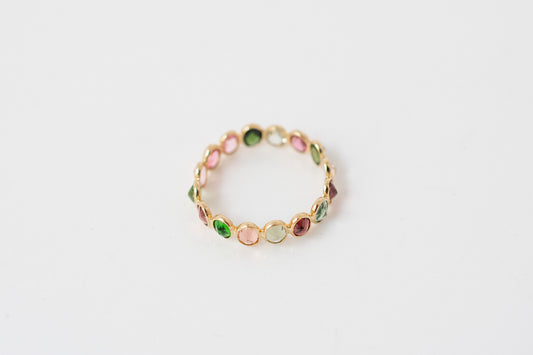 Oval-cut multicolor tourmaline gemstone eternity ring in 18K gold with bezel setting