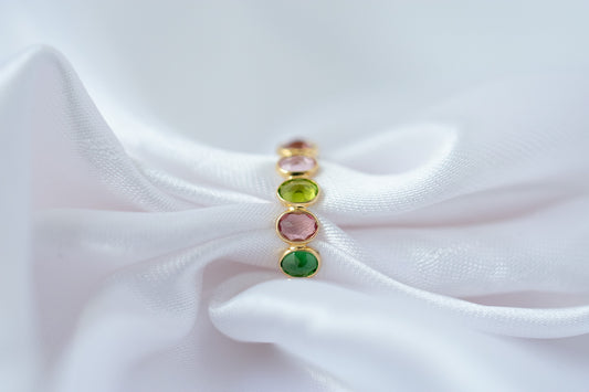 Oval-cut multicolor tourmaline gemstone eternity ring in 18K gold with bezel setting