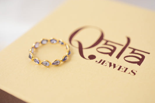 Pear-cut tanzanite gemstone eternity ring in 18K gold with bezel setting