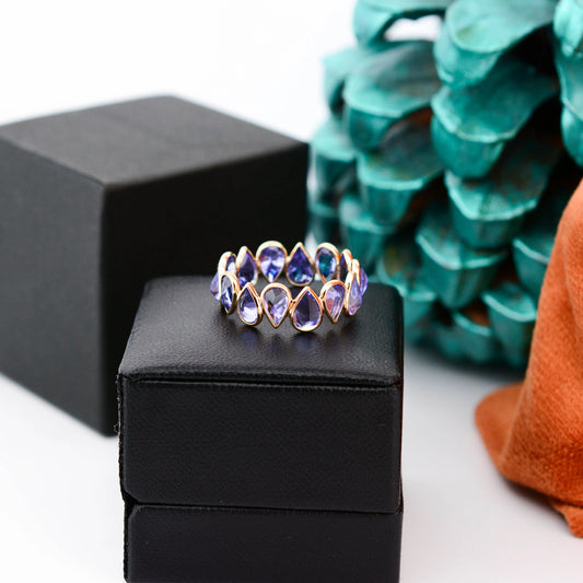 18K gold eternity ring with bezel-set pear-cut tanzanite stones