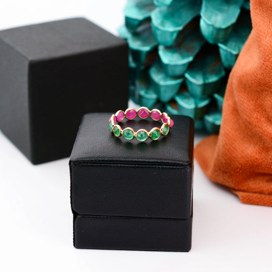 18K gold eternity ring with round-cut emerald and ruby stones in a two-tone design