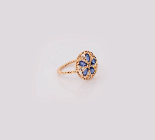18K gold flower cluster ring with blue sapphire petals and a center diamond