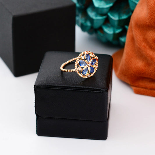 18K gold flower cluster ring with blue sapphire petals and a center diamond