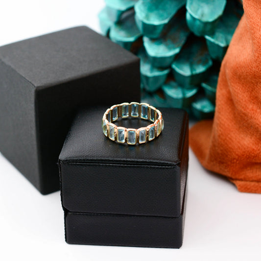 18K gold eternity ring with baguette-cut Swiss blue topaz stones