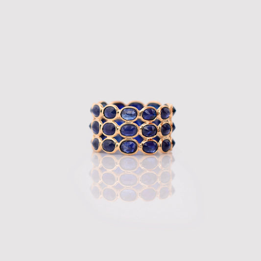 18K gold wide cocktail ring with three rows of bezel-set blue sapphires