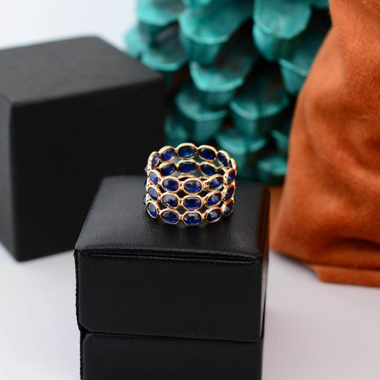 18K gold wide cocktail ring with three rows of bezel-set blue sapphires