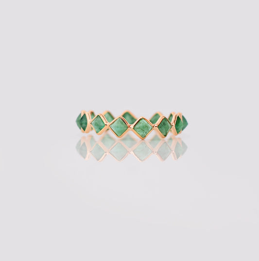 18K gold eternity ring with square and kite-cut emeralds in a zigzag pattern