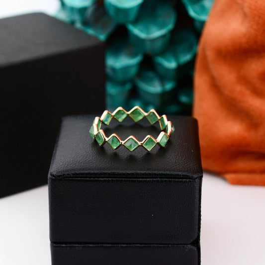 18K gold eternity ring with square and kite-cut emeralds in a zigzag pattern