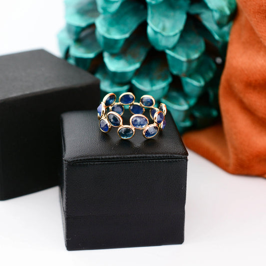 18K gold eternity ring with bezel-set oval-cut blue sapphires