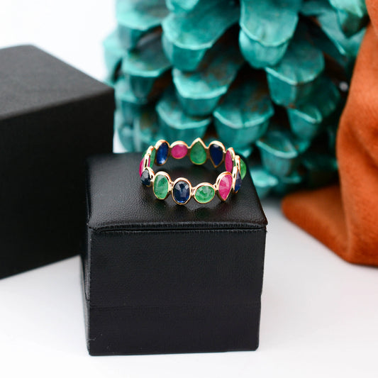 18K gold eternity ring with mixed sapphire, emerald, and ruby gemstones