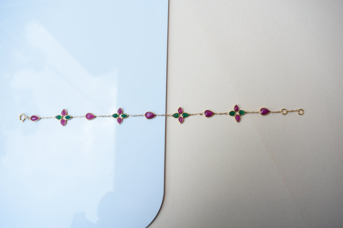 Gold bracelet with ruby and emerald quatrefoil clusters