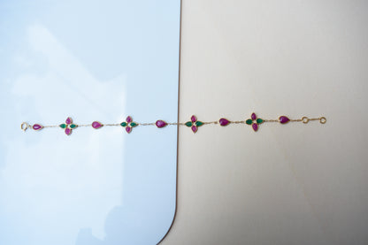 Gold bracelet with ruby and emerald quatrefoil clusters
