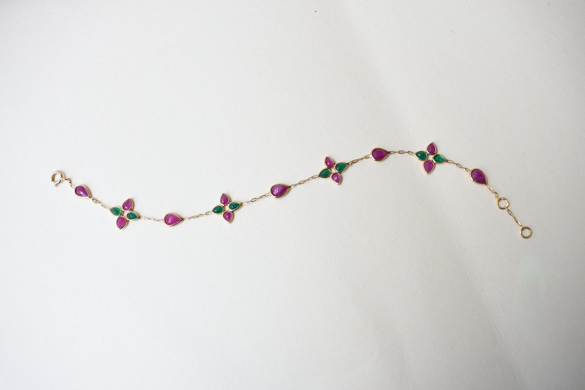 Gold bracelet with ruby and emerald quatrefoil clusters