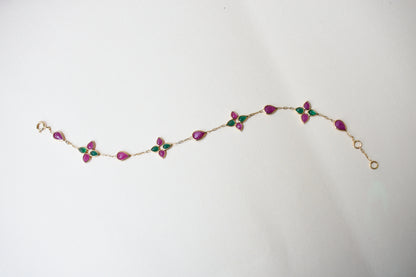 Gold bracelet with ruby and emerald quatrefoil clusters