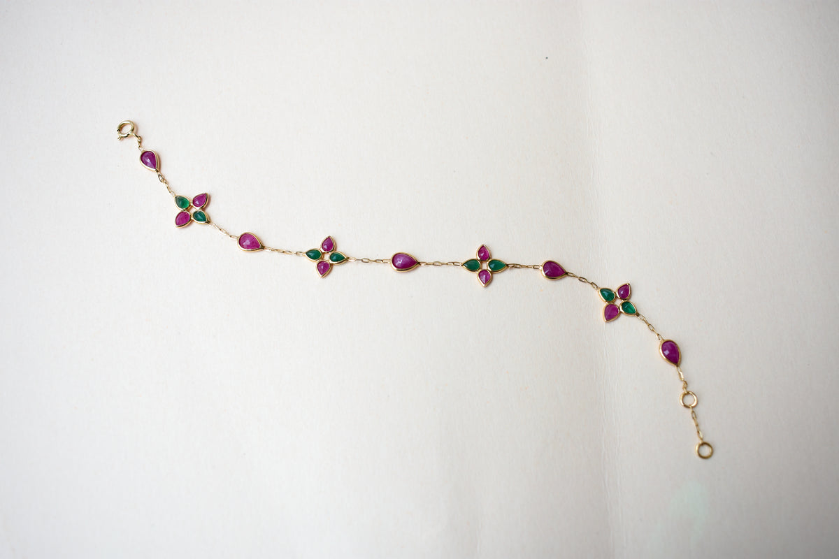 Gold bracelet with ruby and emerald quatrefoil clusters