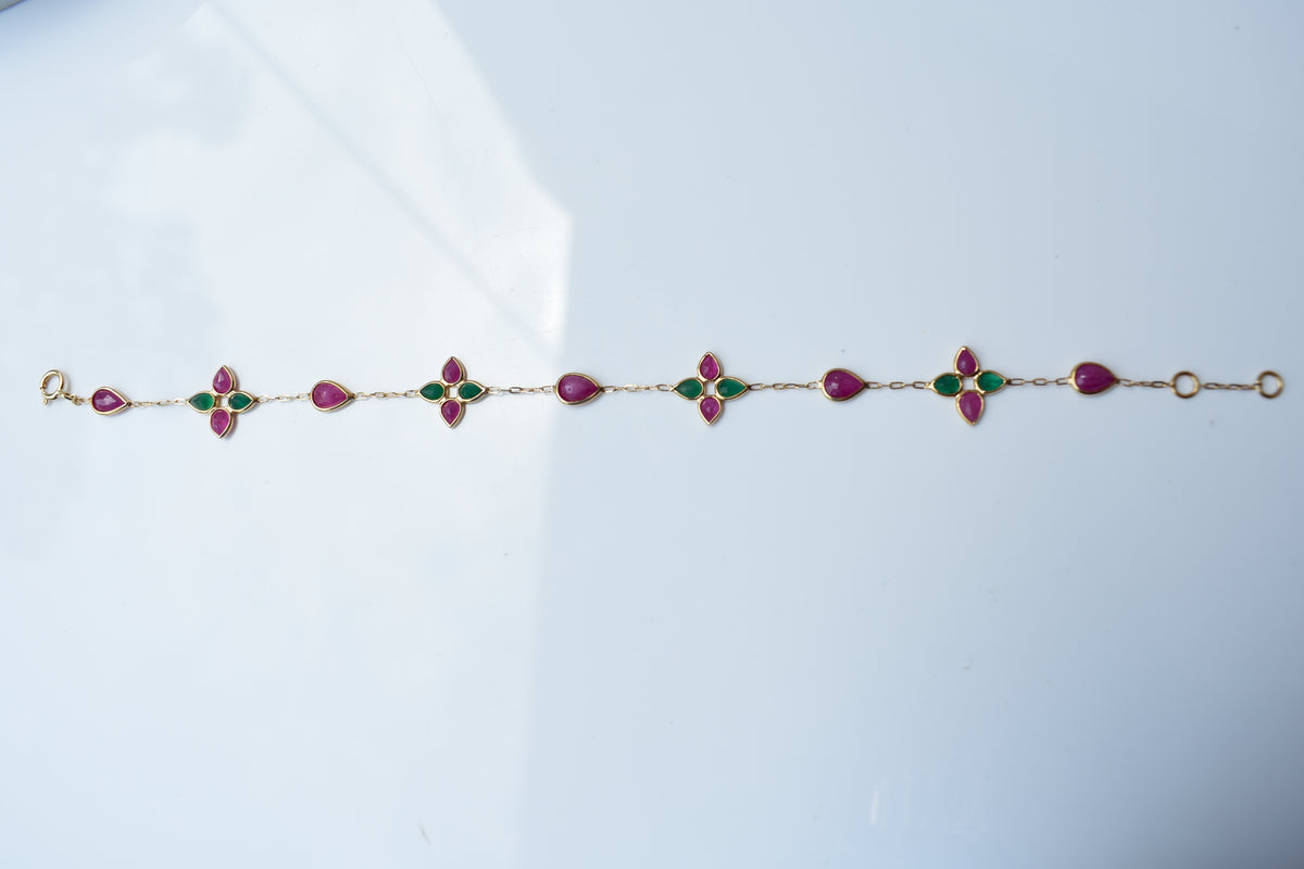 Gold bracelet with ruby and emerald quatrefoil clusters