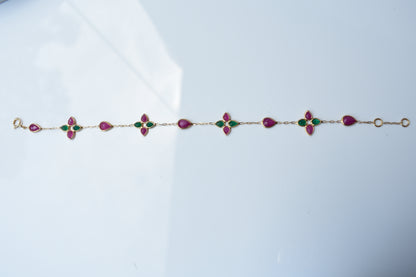 Gold bracelet with ruby and emerald quatrefoil clusters